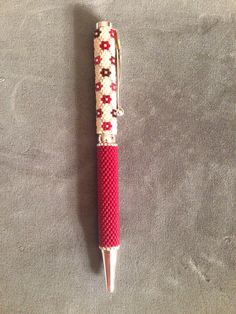 a red and white pen sitting on top of a table