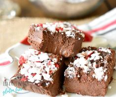 four pieces of chocolate fudge cake on a plate with white and red sprinkles