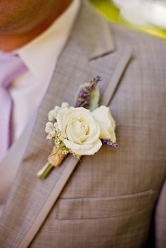 a man in a suit and tie with a boutonniere on his lapel