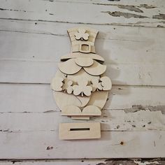 a wooden cutout of a santa clause on a white wood planked wall,