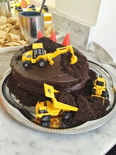 a birthday cake with construction trucks on top and dirt in the middle is featured for pinterest com