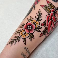 a woman's arm with tattoos on it and flowers around the wrist tattoo design