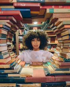 a woman sitting in front of a pile of books