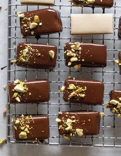 chocolate covered desserts on a cooling rack with nuts and sprinkles around them