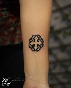 a small tattoo on the wrist of a woman's arm with two intertwined circles