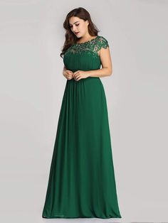 a woman in a long green dress with lace detailing on the shoulders and neckline