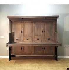 a large wooden cabinet sitting on top of a carpeted floor next to a wall