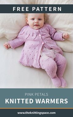 a baby laying on top of a bed wearing a pink knitted sweater and pants