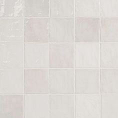 a white tiled wall with small squares on it