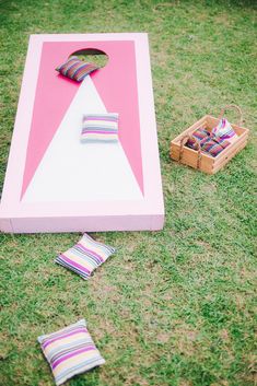 a giant pink and white board game with pillows on the ground next to some other items