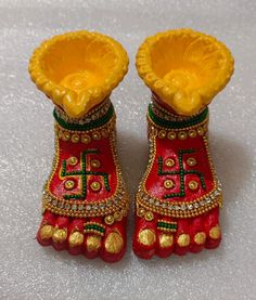 pair of red and gold decorated shoes on white surface