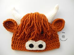 an orange knitted hat with white horns and black eyeballs on the front, made to look like a cow's head