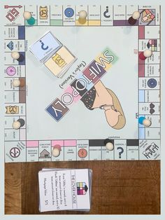 a board game with lots of different items on it and two pieces of paper attached to the board