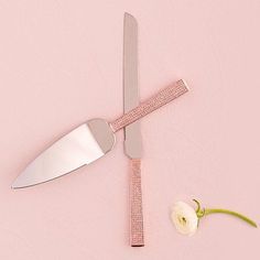 a knife and flower on a pink background