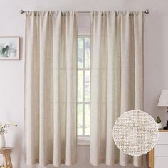 a living room with white walls and curtains on the window sill, next to a dresser