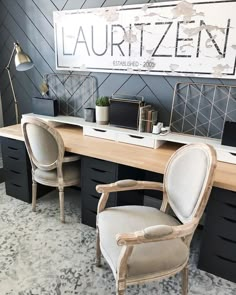 an image of a desk with two chairs and a large sign on the wall above it