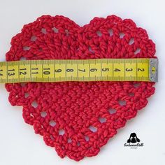 a red crocheted heart with a measuring tape