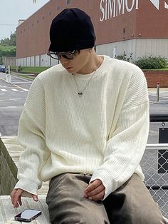 A man dressed in an oversized white sweater, paired with relaxed-fit pants in neutral tones. He accessorizes with a black beanie, dark sunglasses, and a simple silver necklace, creating a laid-back, casual streetwear look. The soft texture of the sweater adds warmth to the outfit, while the beanie and sunglasses provide an urban edge. Soft Boy Fall Outfits, Fall Outfits For Men Autumn, Men’s Winter Clothes, Japanese Fall Fashion Men, White Crewneck Outfit Men, Men’s Fall Fashion 2024 Business Casual, Cozy Men Outfit, Oversized Sweater Outfit Men, Autumn Fits Men