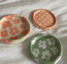 three small dishes sitting on top of a bed