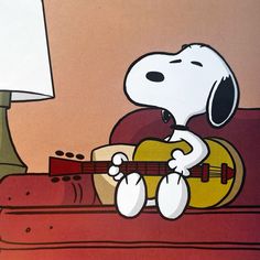 peanuts playing guitar on couch with lamp in background