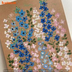 a brown card with blue, pink and white flowers on the front is shown in full color