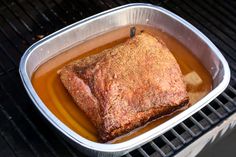 a roasting pan filled with meat on top of a grill