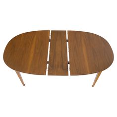 an oval wooden table with four legs and a curved design on the top, against a white background