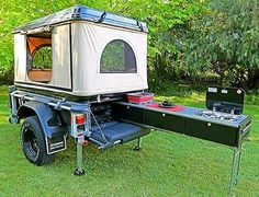 an off - road camper trailer is parked in the grass