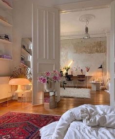 a living room filled with furniture and a large rug on top of a hard wood floor