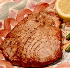 there is a piece of steak on the plate next to an orange and lemon slice