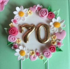 a cake decorated with flowers and the number seventy