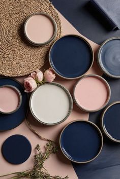 several different shades of paint sitting on top of a table next to a straw hat