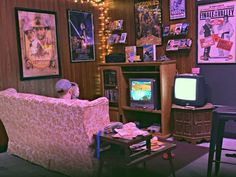 a living room filled with furniture and pictures hanging on the wall above it's tv