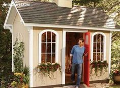 a man is standing in the doorway of a small shed with windows and doors open