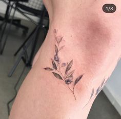 a woman's leg with a small flower tattoo on the lower half of her thigh