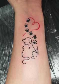 a dog's paw and heart tattoo on the left wrist is shown in black ink