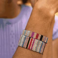 a close up of a person's wrist wearing a bracelet with multicolored beads