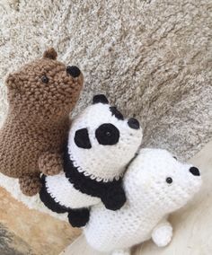 two crocheted stuffed animals sitting next to each other on a carpeted floor