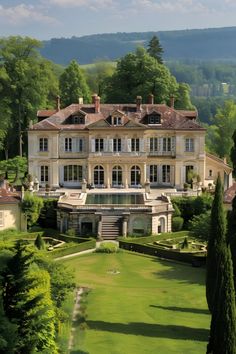 a large house with lots of trees in front of it on a hill above a lush green field