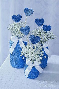 two blue vases filled with baby's breath flowers on top of a table