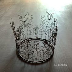 a wire basket with flowers on it sitting on a table