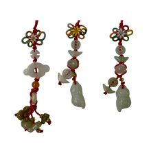 three wind chimes hanging from strings on a white background