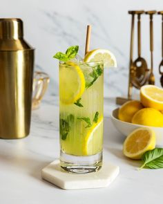 a glass filled with lemonade and mint on top of a counter