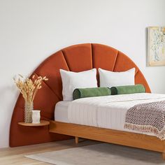 a bed with an orange headboard and white pillows on it, in a bedroom