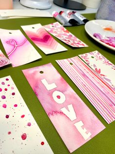 valentine's day cards are laid out on a table with paint and watercolors