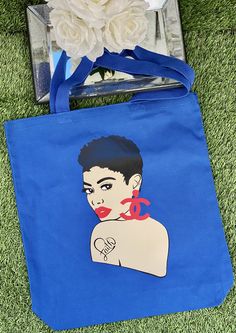 a blue tote bag with an image of a woman's face on it