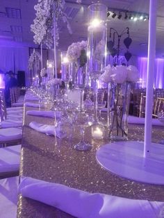 the tables are set up with white flowers and silver sequins for an elegant wedding reception