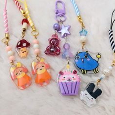 several keychains with various designs on them sitting on a white furnishing