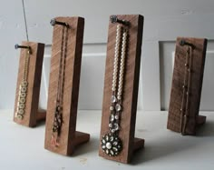 three pieces of wood with beaded necklaces on them