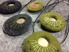 four different colored stones with beaded designs on them sitting on a table next to some cords